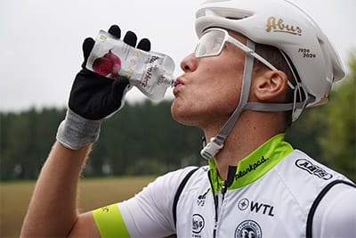 Lukas Kaufmann trinkt einen Bio Rüben Herz Shot beim Mountainbiken